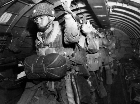 U.S. paratroopers on D-Day U.S. paratroopers fix their static lines before a jump before dawn over Normandy on D-Day June 6, 1944, in France. The decision to launch the airborne attack in darkness instead of waiting for first light was probably one of the few Allied missteps on June 6, and there was much to criticize both in the training and equipment given to paratroopers and glider-borne troops of the 82nd and 101st airborne divisions. Improvements were called for after the invasion; the hard-won knowledge would be used to advantage later. (AP Photo/Army Signal Corps)