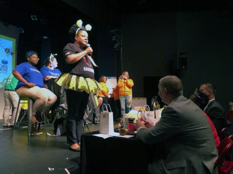 Emcee Valerie Guzman addresses the crowd at Imagination Library of Montgomery County’s last Grown-Up Spelling Bee. This year’s event will be held September 27 at the Customs House Museum, presented by Two Rivers Electric. 